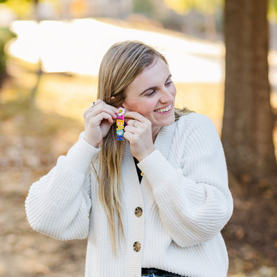 Model wearing a pair of Beaded Floral TEACH Earrings for teachers.